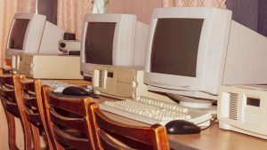 a row of three old 90s or 2000s computers